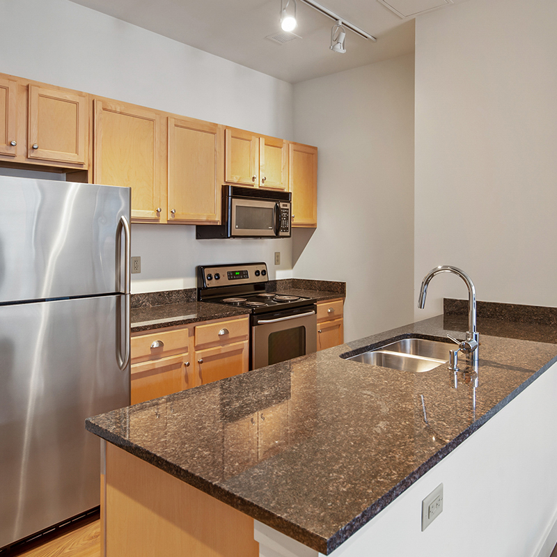 Apartment kitchen with black granite countertops and studio light
