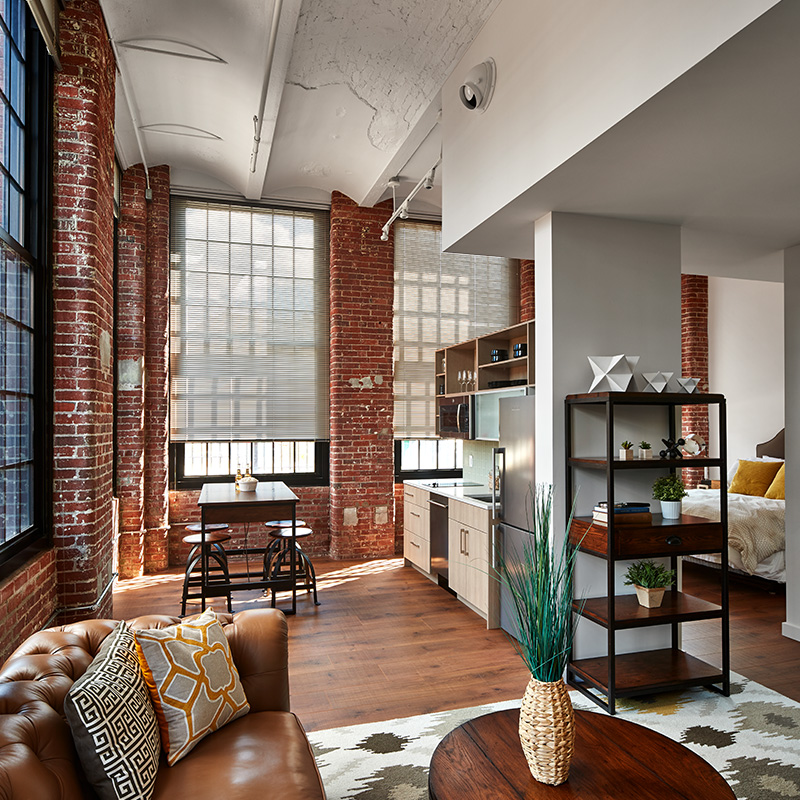 Studio apartment with medium wood floors and patterned textiles